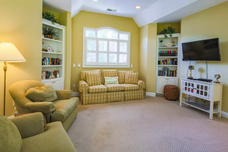 The family room features a comfortable seating area and wall-mounted TV.