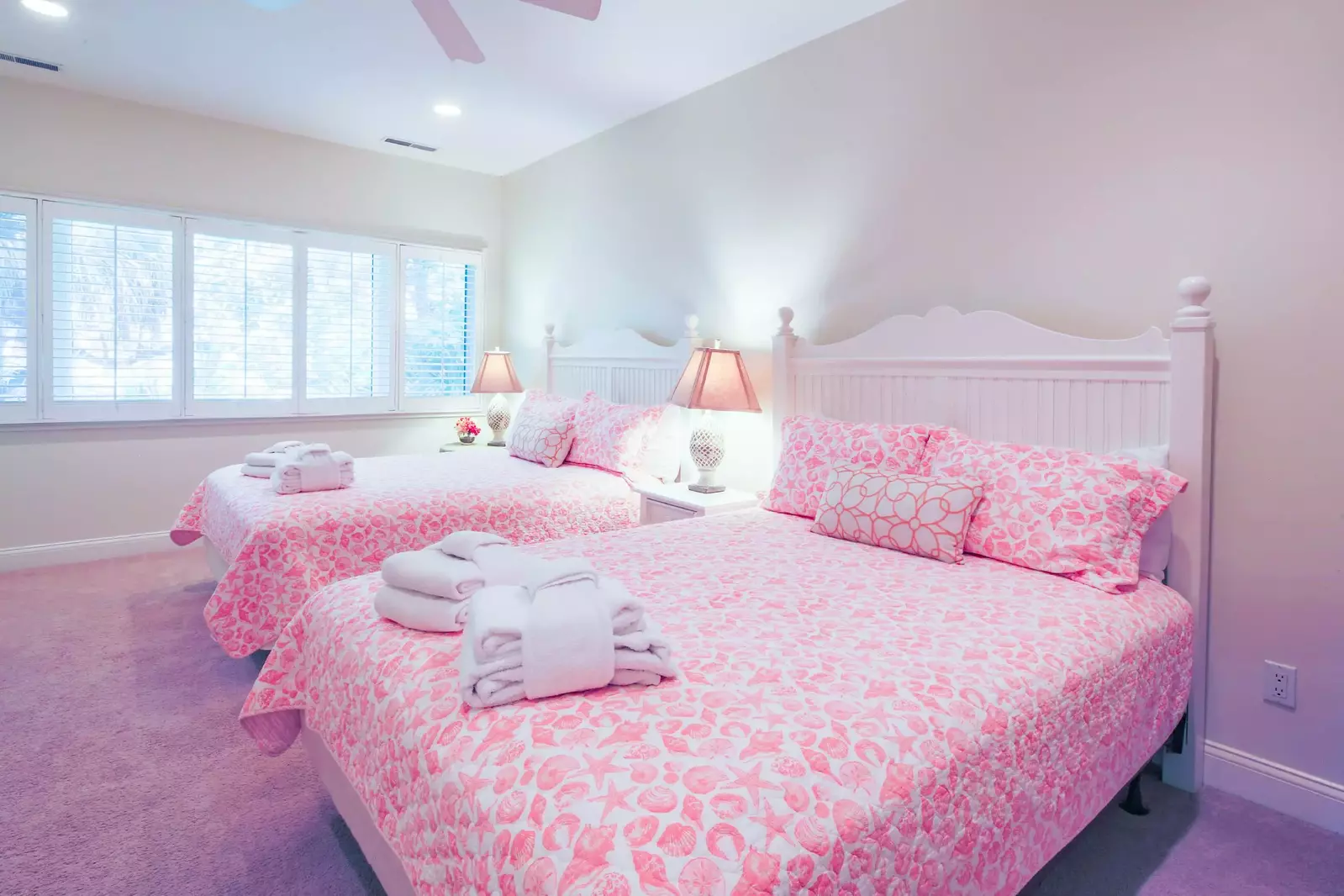 The queen suite features two queen beds and night stands with reading lamps.