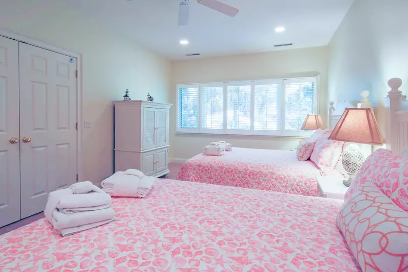 This queen suite also featues a ceiling fan, TV within an armoire and an en suite bathroom.