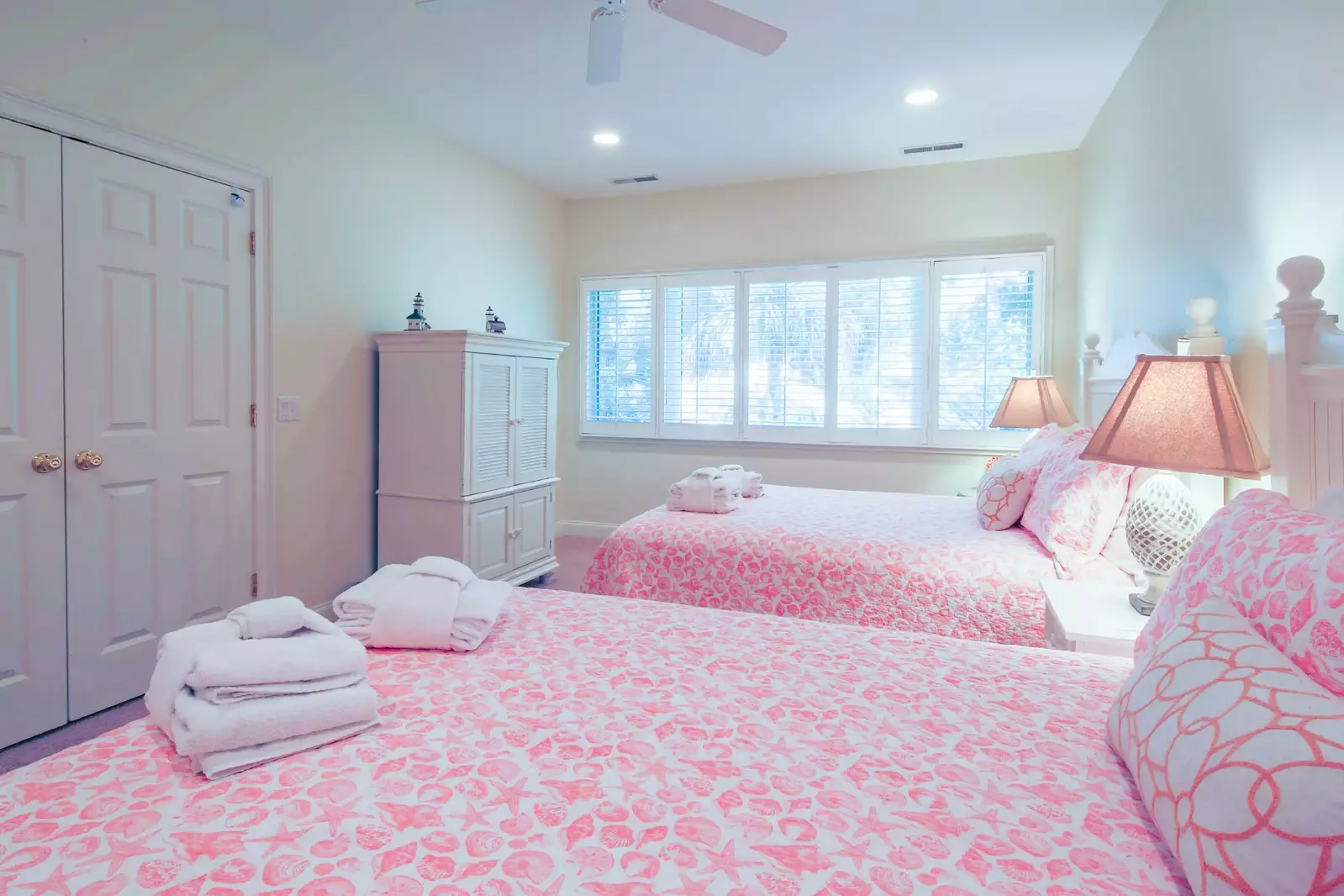 This queen suite also featues a ceiling fan, TV within an armoire and an en suite bathroom.