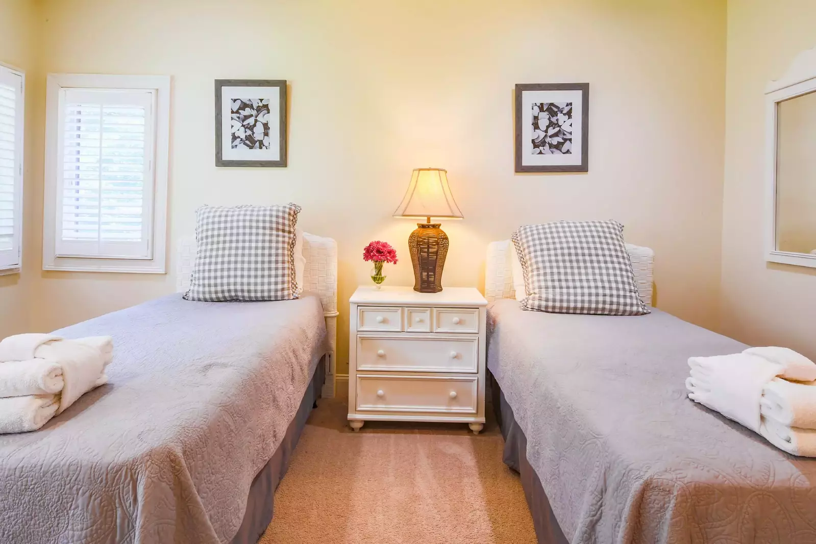 The twin suite features two twin beds and a night stand with a reading lamp.