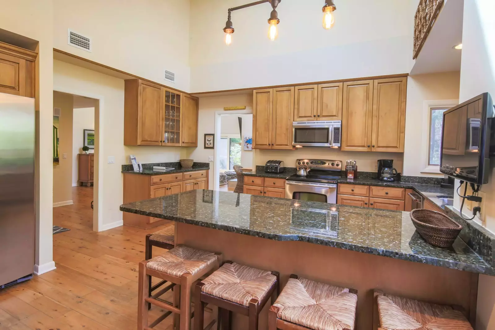 The spacious kitchen features granite countertops, stainless steel appliances and a vaulted ceiling.