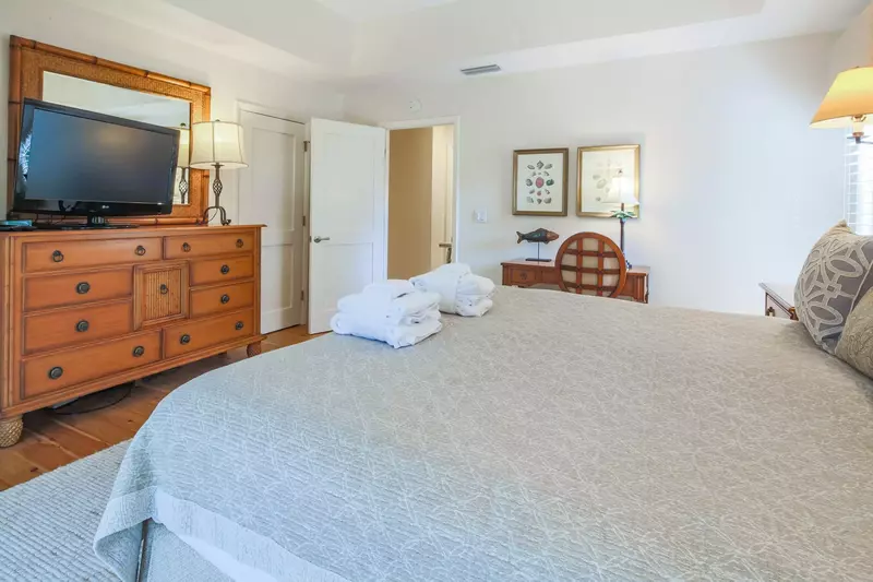 The master suite also features a dresser, flat screen TV and a desk.