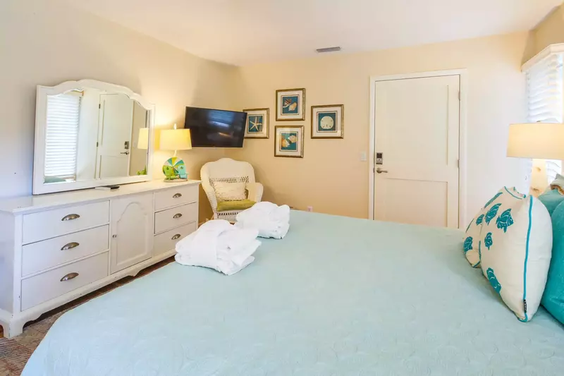 The second master suite also features a dresser and wall-mounted flatscreen TV.