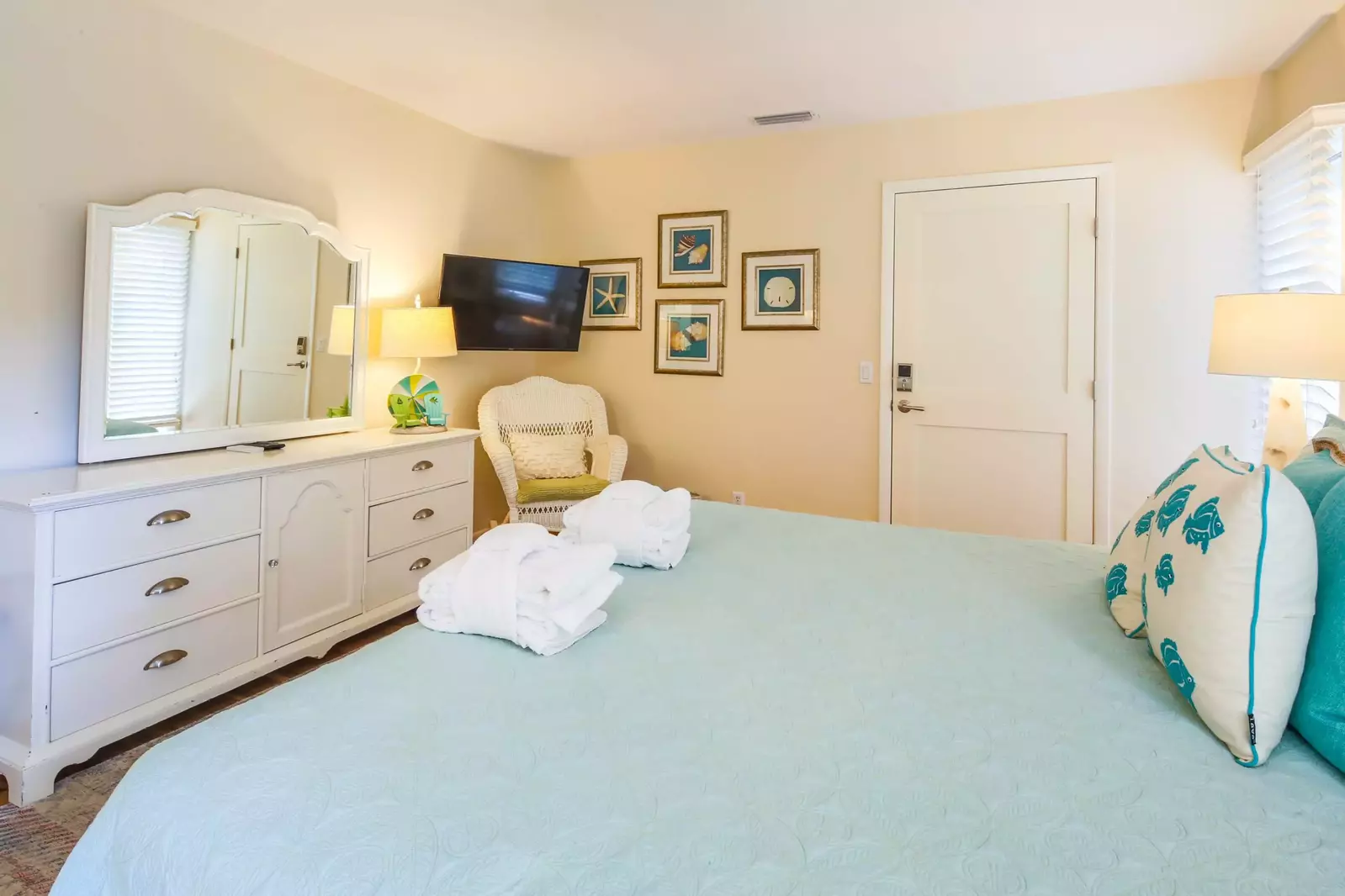 The second master suite also features a dresser and wall-mounted flatscreen TV.