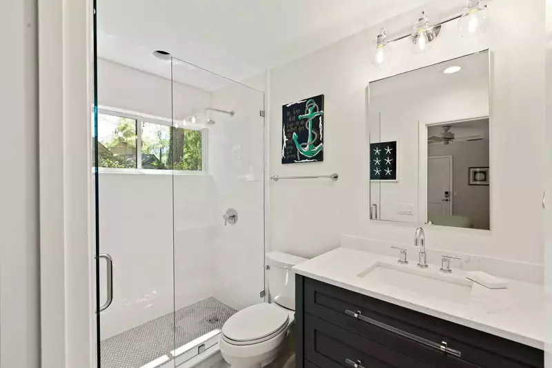 The en suite bathroom features a spacious vanity and a tiled, walk-in shower.