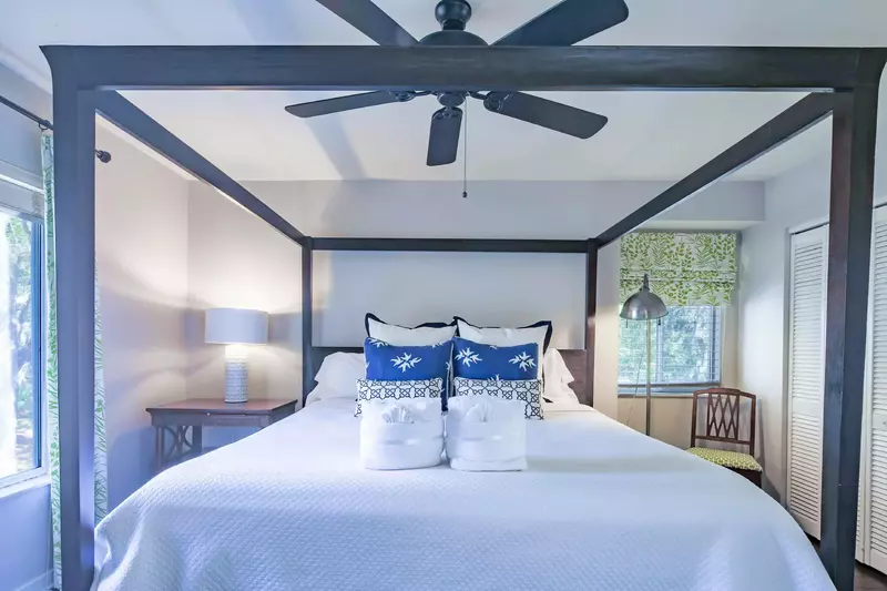 The master suite features a king bed with night stand and reading lamps.