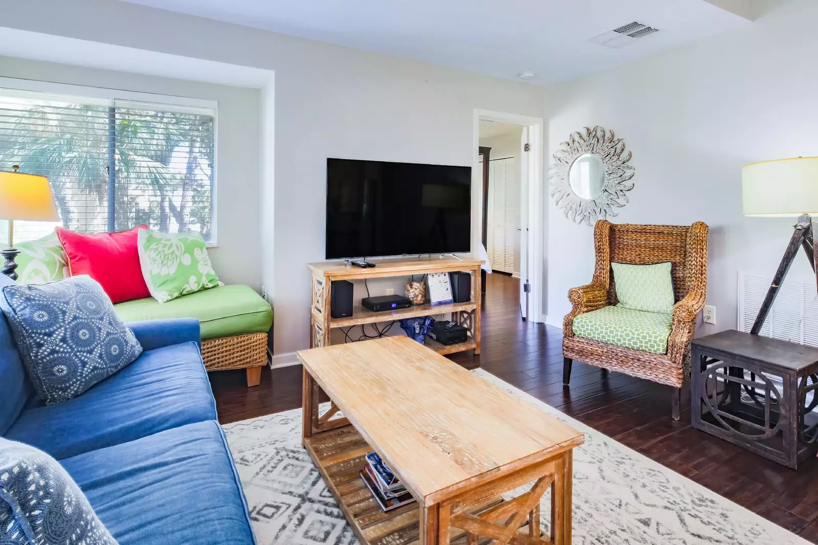 The living room features a sofa, chaise lounge chair and flat screen TV.