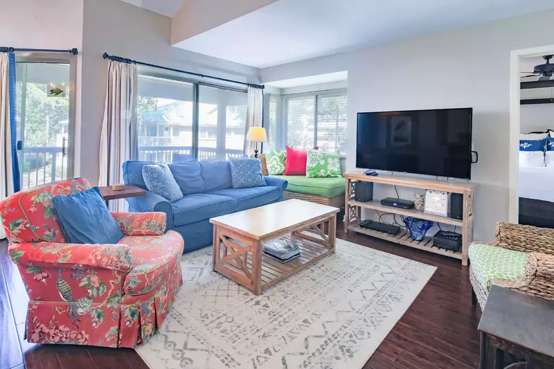 The living room receives lovely natural light through the many windows & sliding glass doors in the room.
