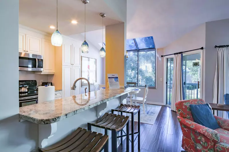 The kitchen opens into the living room, dining area and covered balcony.