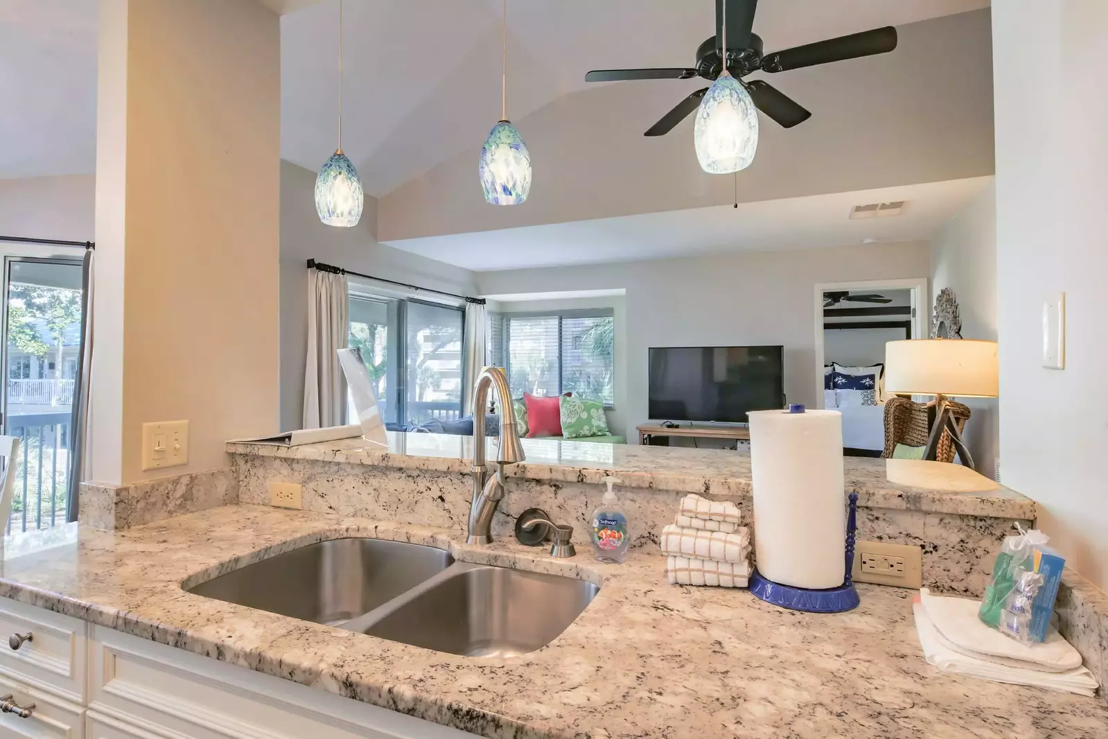 The kitchen features granite counters, pendant lighting and white cabinets.
