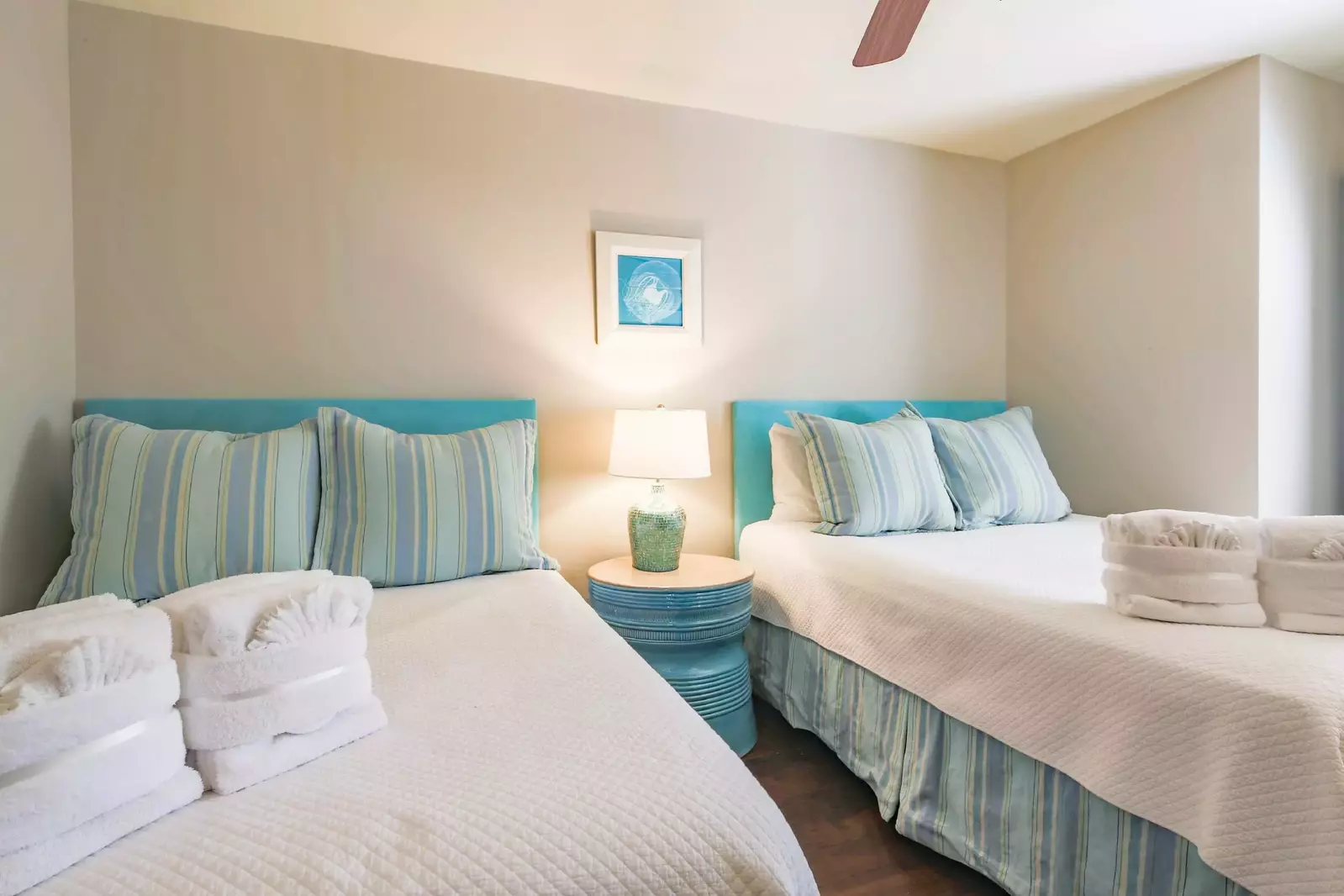 The guest bedroom features a queen bed, a full bed and a night stand with a reading lamp.