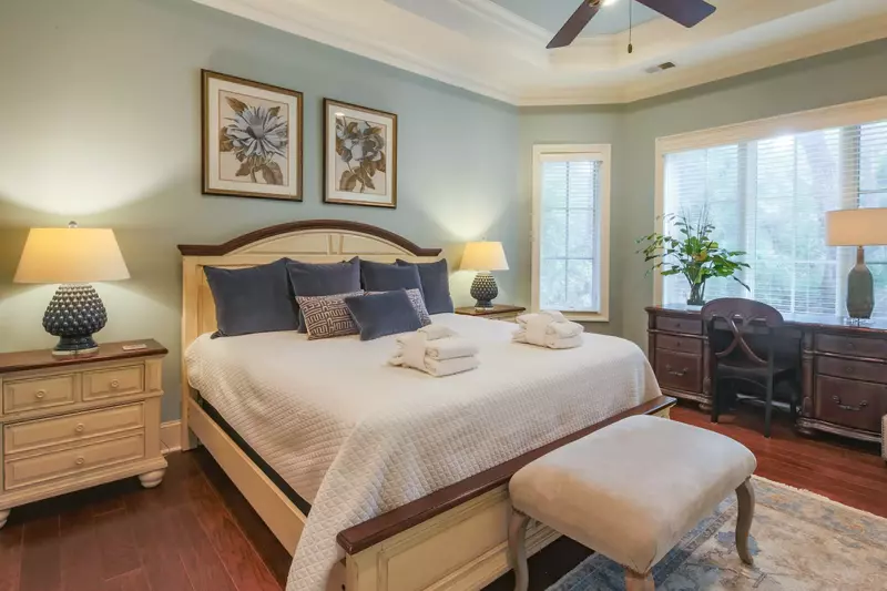 The master suite features a king bed and views of the backyard & pool area.