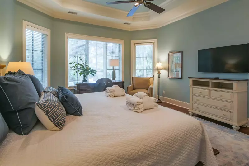There is also an arm chair, desk, dresser, wall-mounted TV and ceiling fan in the master suite.