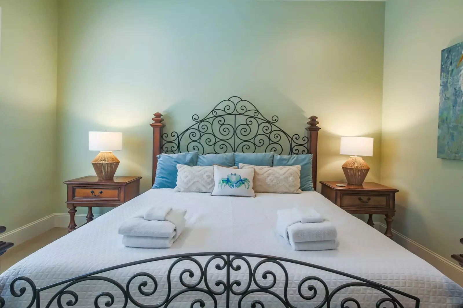 There is a night stand with reading lamp on both sides of the king bed.