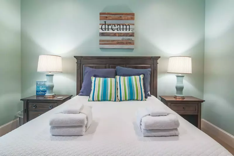 There is a nightstand with reading lamp on both sides of the queen bed.