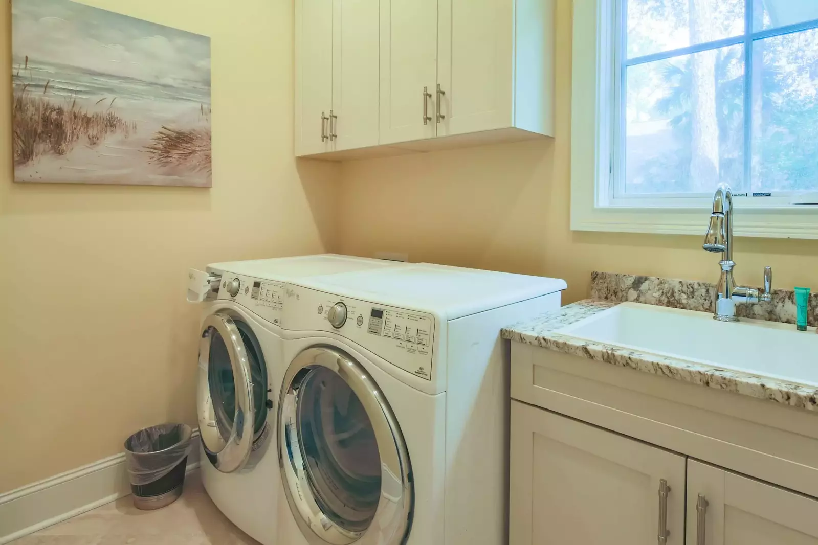 There is a laundry room with full-sized washing machine and dryer within the home.