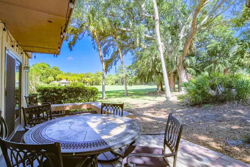 The back deck features an outdoor dining table & chairs and views of the second hole of the Robert Trent Jones golf course.