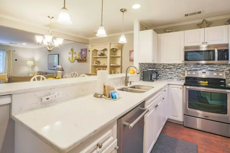 The beautiful kitchen features quartz counters, stainless steel appliances and white cabinets.