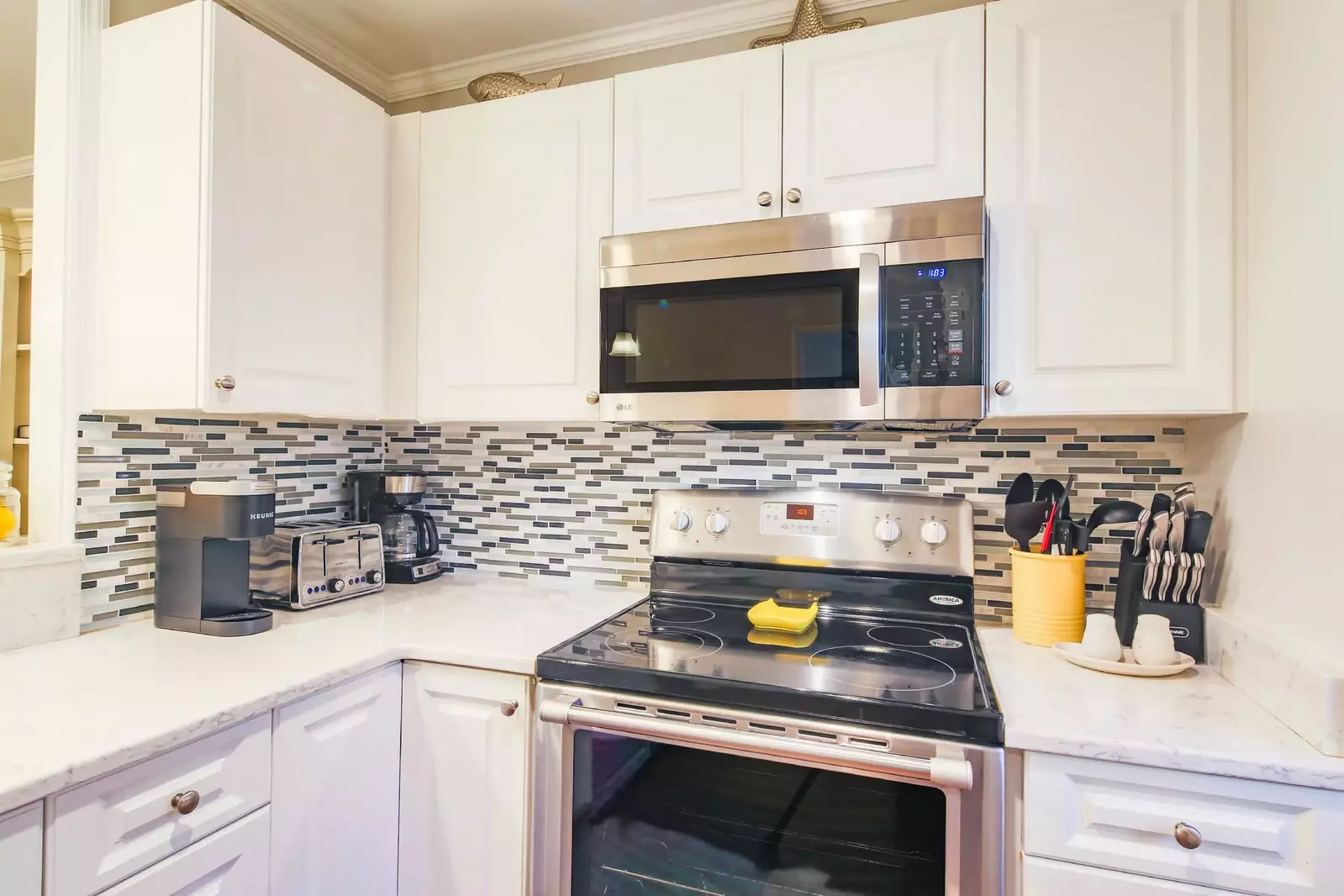 There is also a tiled backsplash, drip coffee maker and keurig in the kitchen.