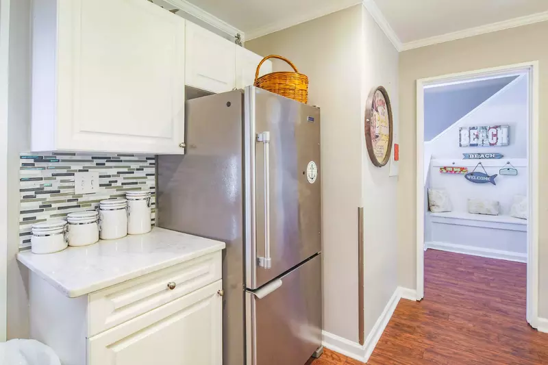 The kitchen connects to the entryway hallway and stairs to the second floor.
