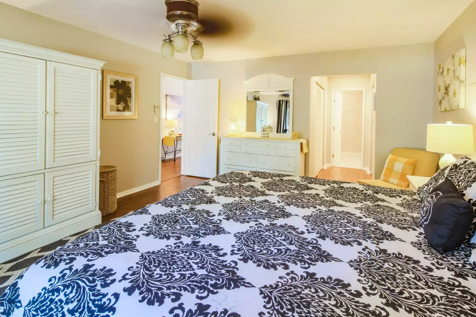 The primary suite also features an armoire, dresser, chair and en suite bathroom.