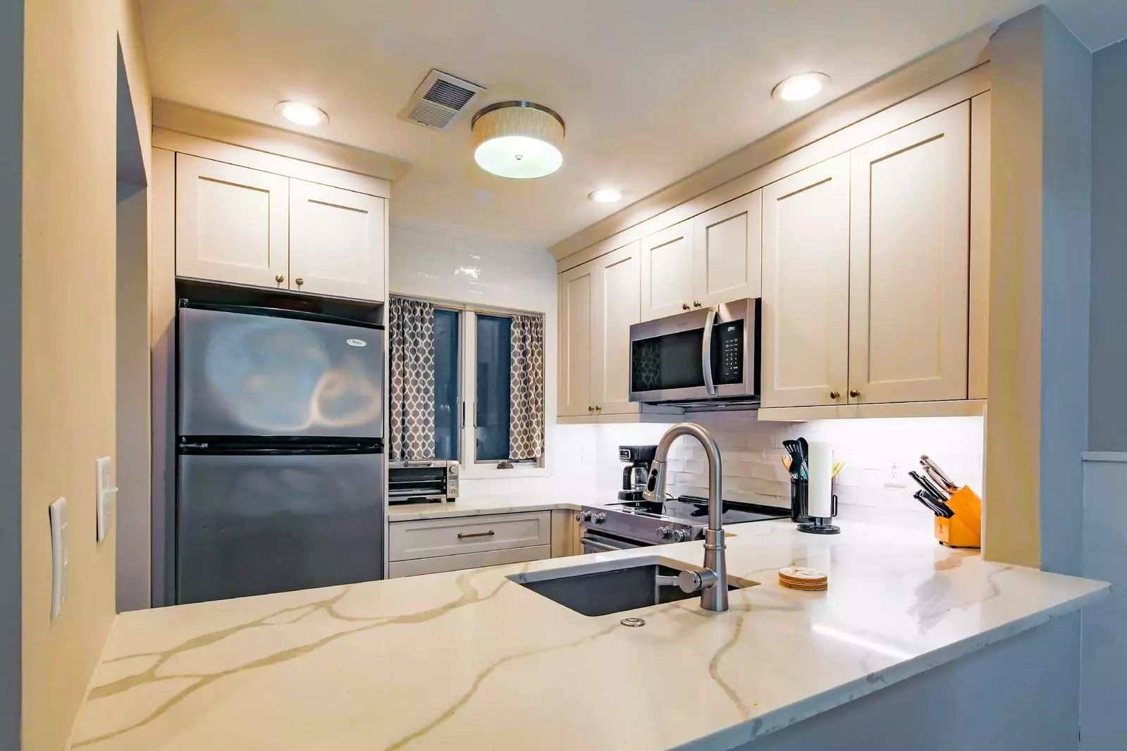 Ocean Vista features a gorgeously renovated kitchen with white cabinets, tiled backsplash and granite countertops.