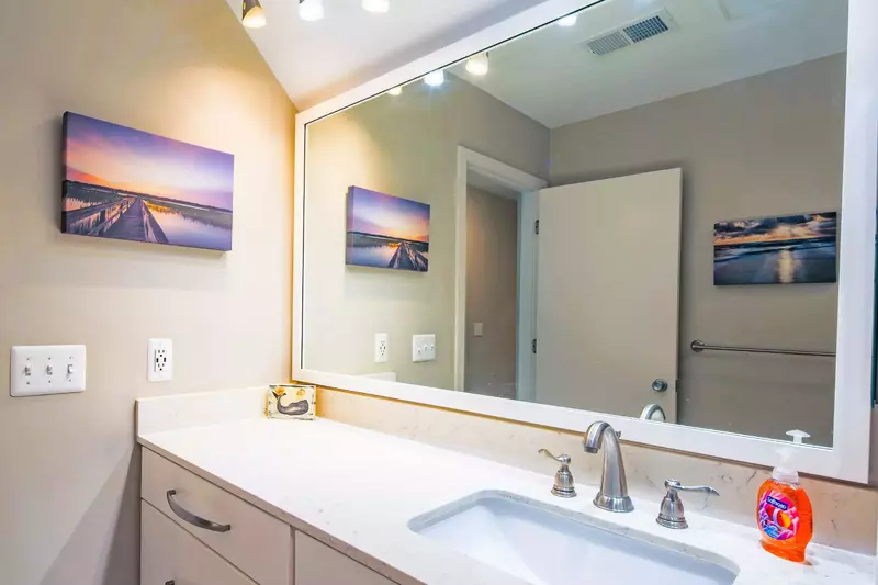 The bathroom has a wide vanity with lots of storage space and counter area.