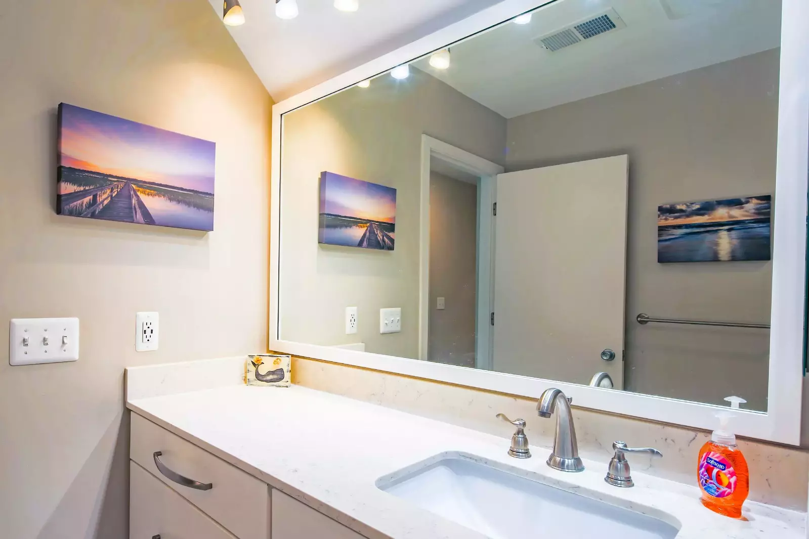 The bathroom has a wide vanity with lots of storage space and counter area.