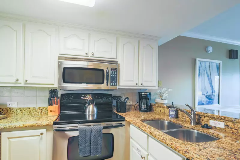 The kitchen features stainless steel appliances and granite countertops.