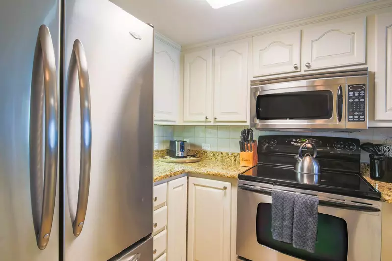 The kitchen features a refrigerator, toaster, microwave and range.