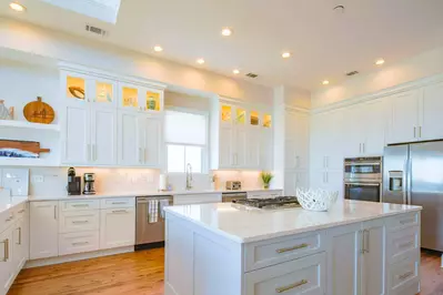 The kitchen also features a refrigerator, oven and central island with gas cook top.