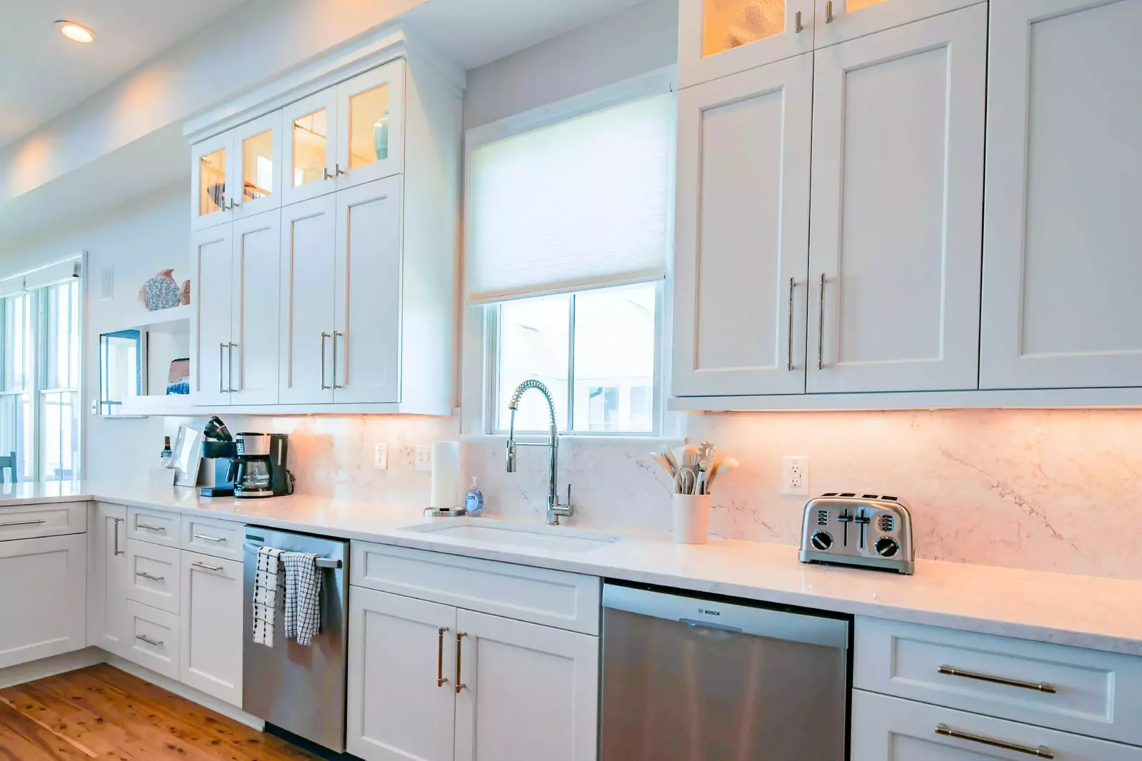 The newly renovated kitchen features two dishwashers, white cabinet and gorgeous granite counters.