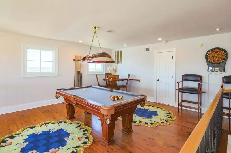 The third floor of the home features a game room with a pool table, dart board and card table.