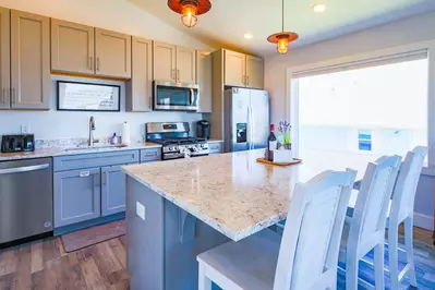 The beautiful kitchen features a central island, granite countertops and stainless steel appliances.