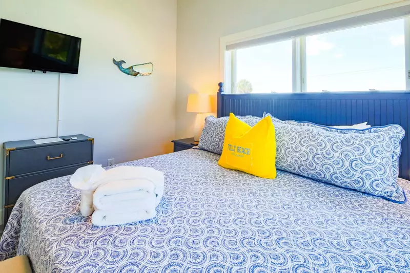 The master suite also has a dresser and wall-mounted smart TV.