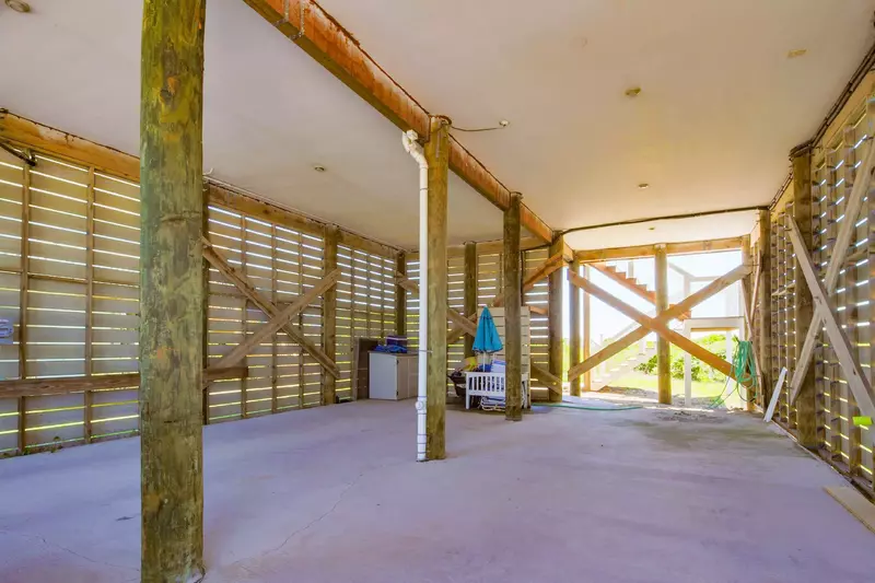 Walk through the carport to find the stairs on the oceanside of the home that lead to the back deck and entryway for the house.