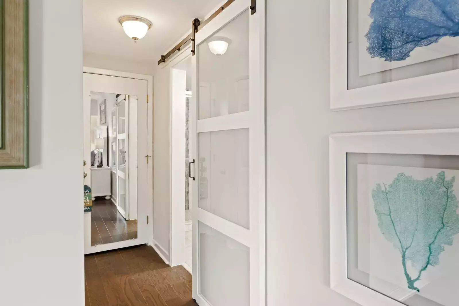 Barn door leading to en suite bath in primary bedroom