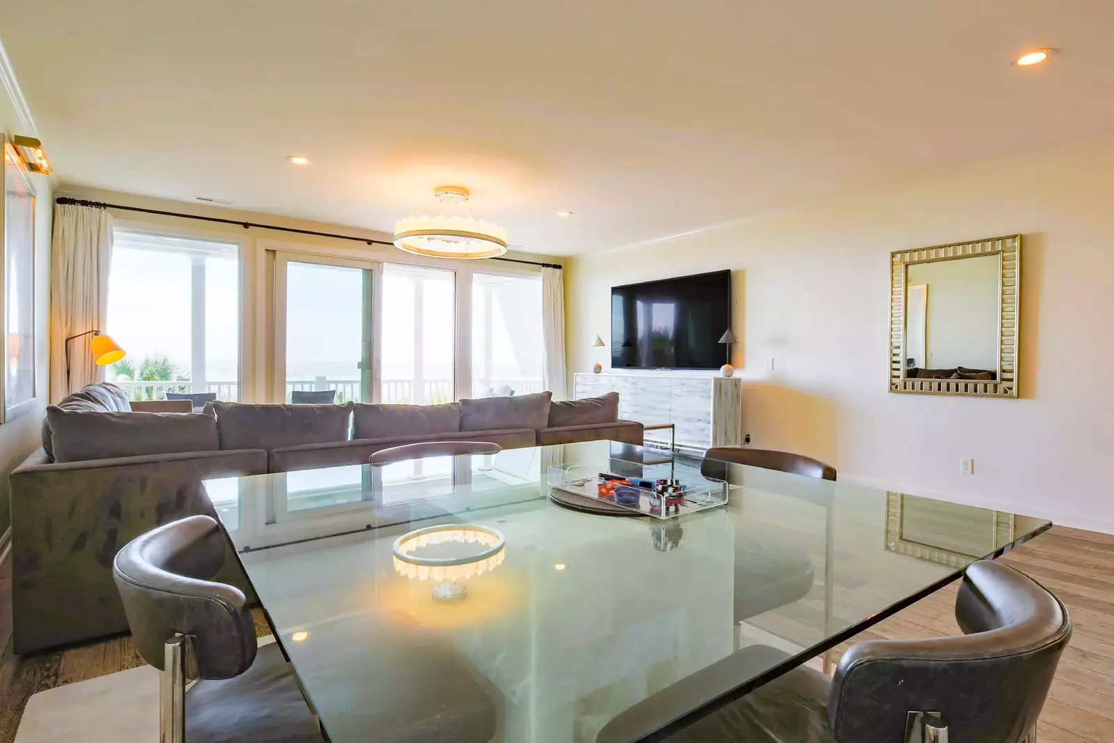 The dining table looks out into the living room and the covered balcony off of the living room.