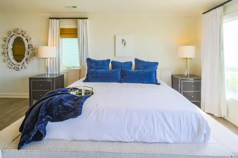 The primary suite, which is located on the second floor, features a king bed and night stands with reading lamps.