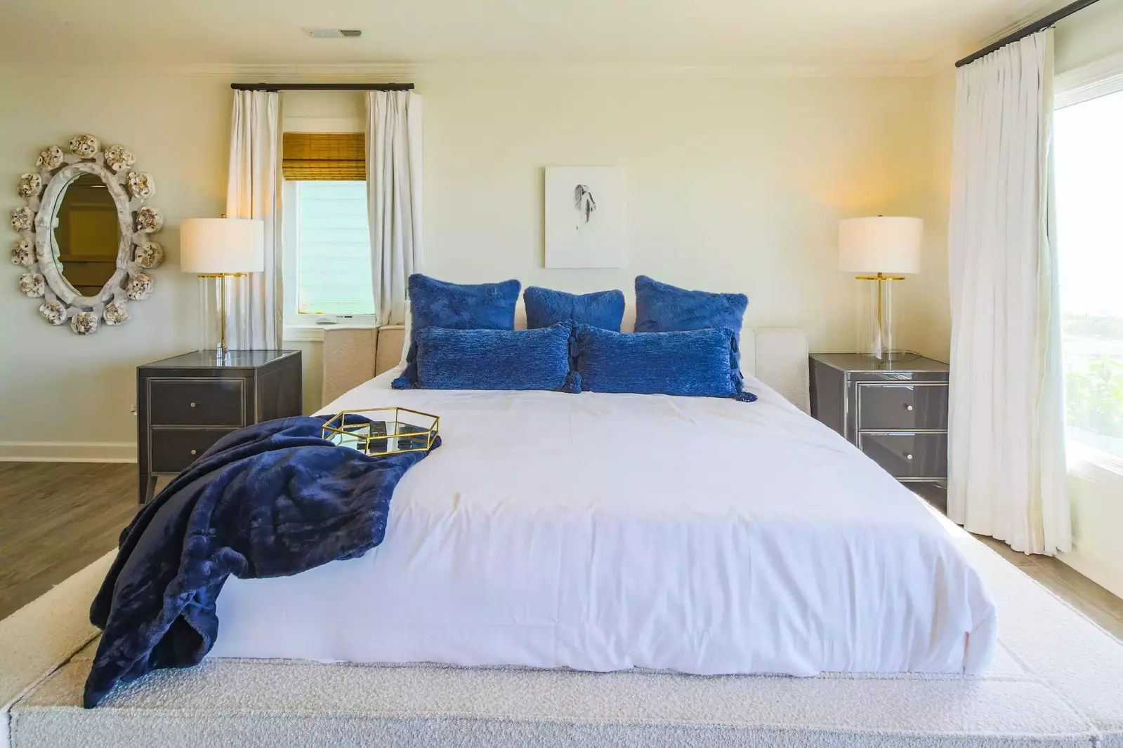 The primary suite, which is located on the second floor, features a king bed and night stands with reading lamps.