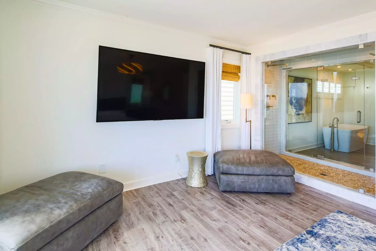 The primary suite has a wall-mounted TV and a double glass walled shower.