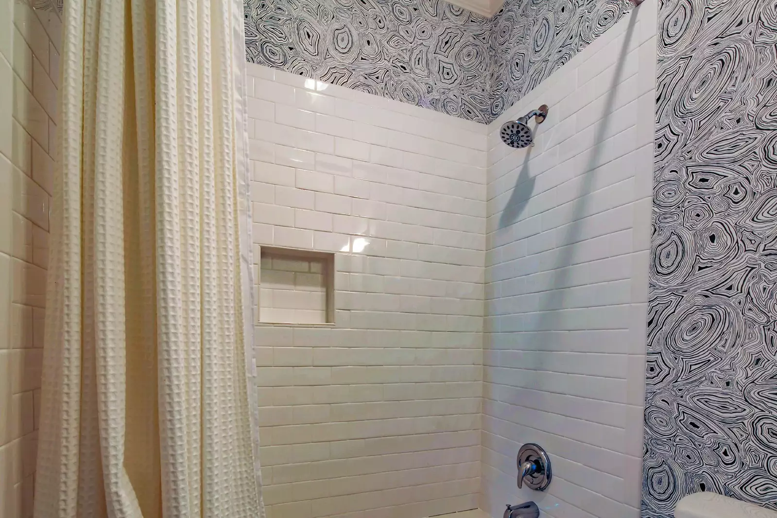The en suite bathroom also features a tiled, shower/tub combo.