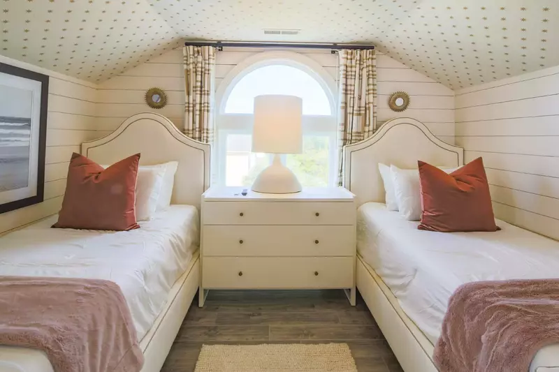 The two twin beds are separated by a night stand with a reading lamp.