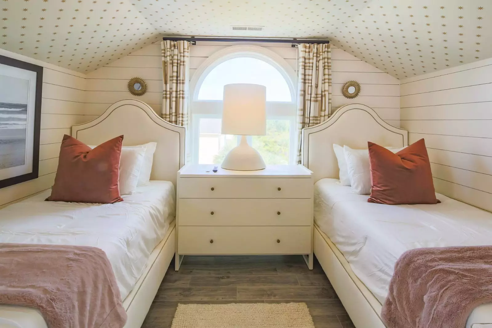 The two twin beds are separated by a night stand with a reading lamp.