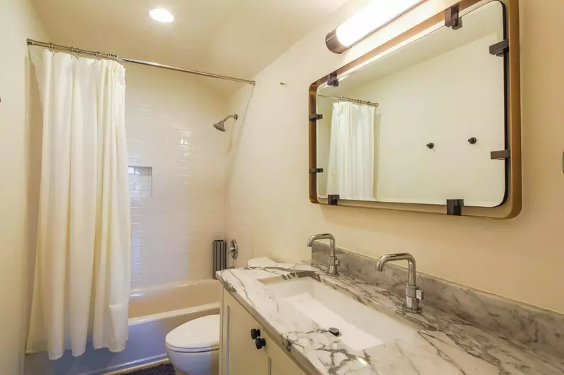 The en suite bathroom features a spacious vanity and shower/tub combo.