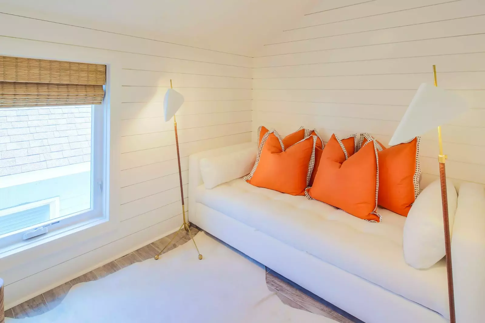 This bedroom on the third floor features shiplap walls and a sleeper sofa.