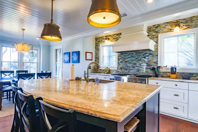 The kitchen centers around the island with granite counters, pendant lighting and 6 stools.