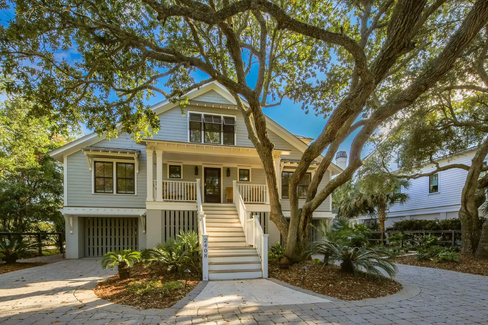 The front of the house is surrounded with live oak trees, palmetto trees and other beautiful landscaping.