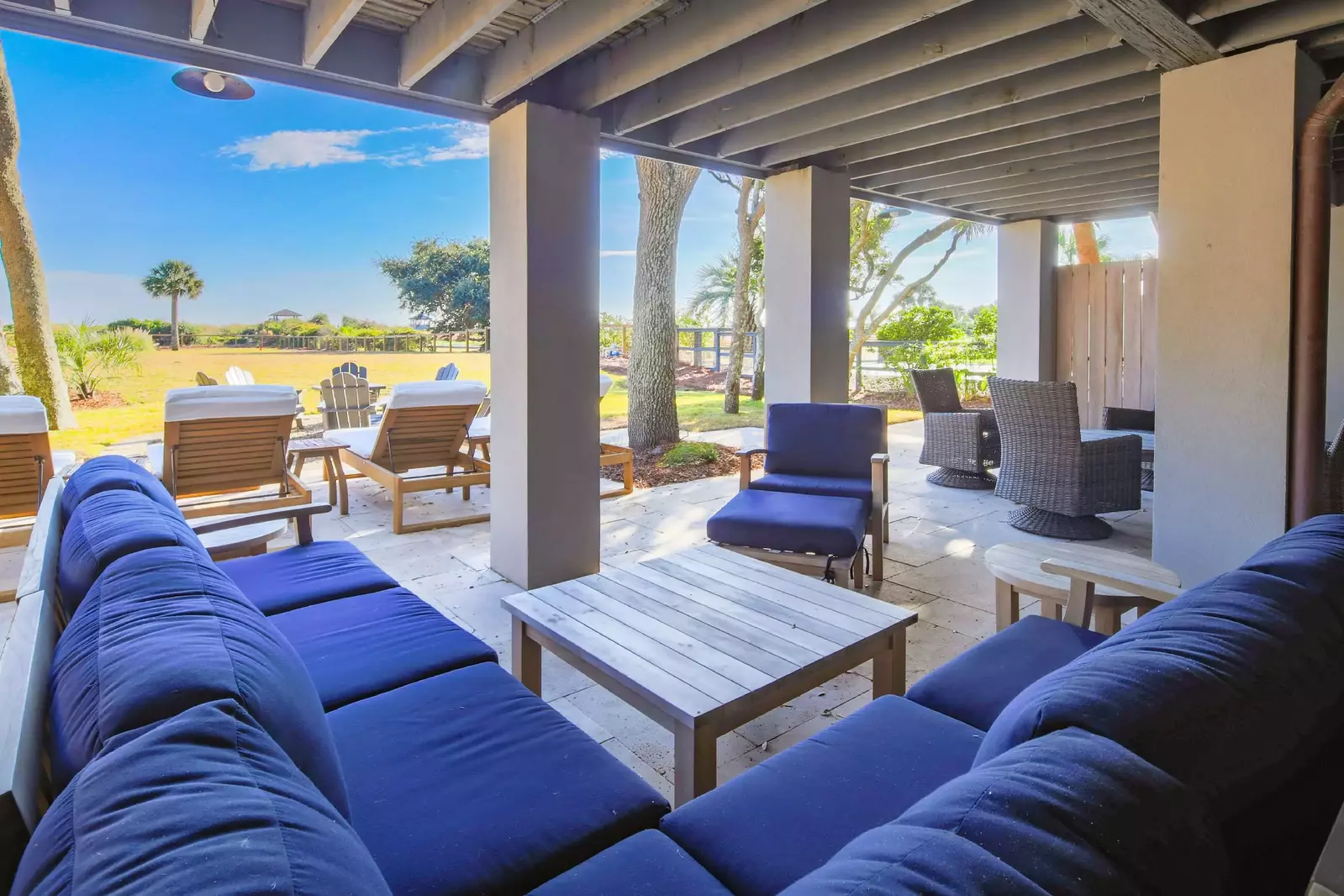 The lowest level on the oceanside of the house features a partially-covered patio with multiple seating areas.
